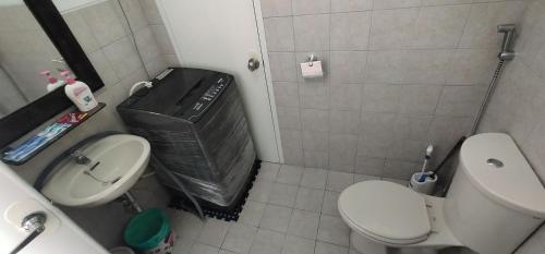 een kleine badkamer met een toilet en een wastafel bij Molave Model House in Pook