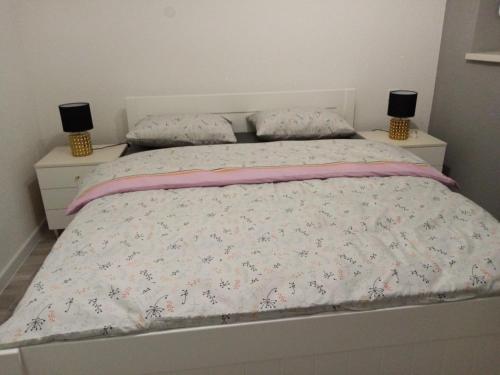 a bedroom with a bed with two nightstands and two lamps at Apartman Ćetojević in Banja Luka