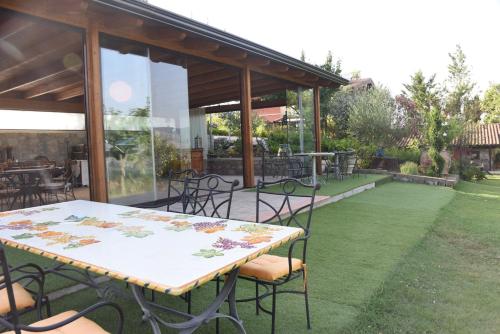 a patio with a table and chairs on a lawn at Bosco D'Olmi Country House in SantʼAndrea del Garigliano