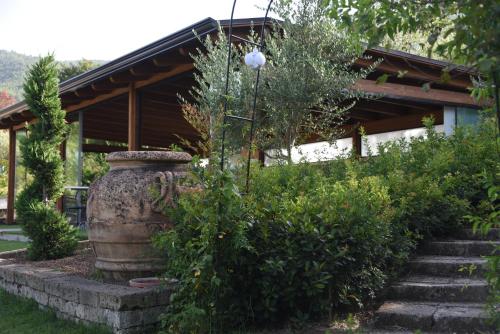 a garden with a large planter in front of a house at Bosco D'Olmi Country House in SantʼAndrea del Garigliano