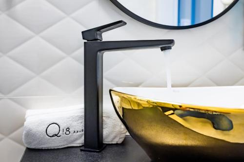 a bathroom with a sink and a mirror at Q18 ApartHotel in Bydgoszcz