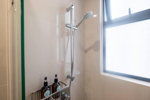 a shower in a bathroom with a window and bottles at Endless Warming~ 2BR5Pax Southlink Bangsar South in Kuala Lumpur