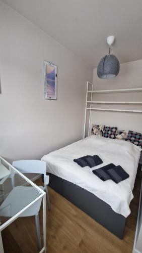 Apartament Wieliczka في فياليتشكا: غرفة نوم صغيرة مع سرير مع ملاءات بيضاء
