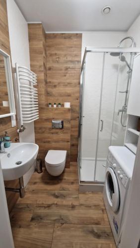 a bathroom with a shower and a toilet and a sink at Apartament Wieliczka in Wieliczka