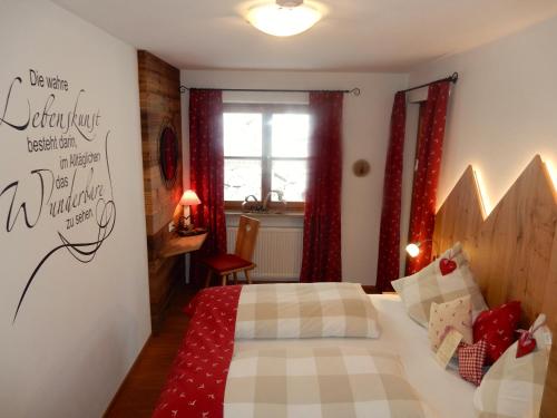 a bedroom with a bed with a red and white blanket at Gästehaus Schönfeld in Reit im Winkl
