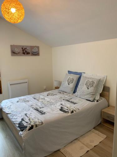 ein Schlafzimmer mit einem großen Bett mit weißer Bettwäsche und Kissen in der Unterkunft Le paradis des oiseaux in Saint-Gildas