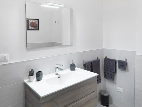 a white bathroom with a sink and a mirror at La Casa di Cri in Bologna