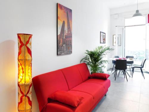 La Casa di Cri في بولونيا: أريكة حمراء في غرفة معيشة مع طاولة