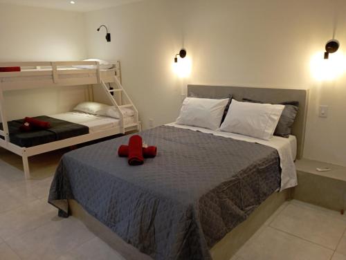 a bedroom with a bed with a red ribbon on it at Pousada Casa Do Cocotier in São Miguel do Gostoso