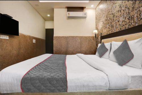 um quarto com uma grande cama branca com almofadas em Shree Apartment em Jhansi