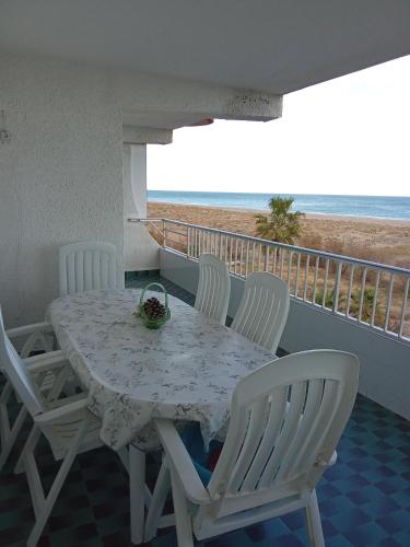 uma mesa e cadeiras numa varanda com praia em Apartamento tradicional em Canet d'En Berenguer