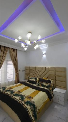 a bedroom with a large bed with a purple ceiling at 3 bed apartments at awoyaya, ibeju lekki. Lagos. in Awoyaya