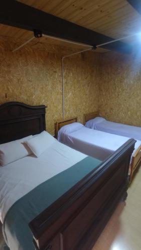 two twin beds in a room with a wall at Casa Hebe - En las sierras de Córdoba - cuenta con tres habitaciones y capacidad para 8 personas, tranquila con increibles vistas in Villa Parque Siquiman