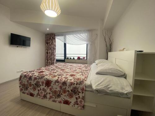 a bedroom with a bed with a floral bedspread at Lake House - Bucuresti in Bucharest
