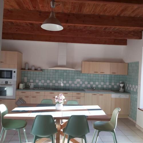 - une cuisine avec une table et des chaises vertes dans l'établissement Résidence KREIZ AN AVEL, à Plobannalec-Lesconil