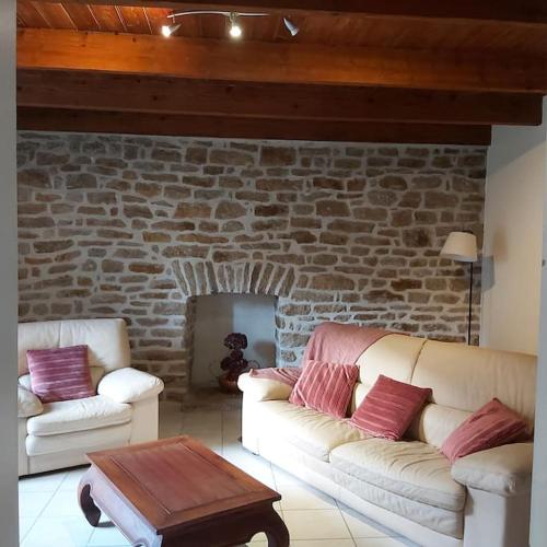 - un salon avec deux canapés et un mur en briques dans l'établissement Résidence KREIZ AN AVEL, à Plobannalec-Lesconil