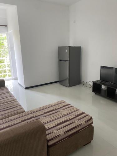 a living room with a refrigerator and a couch at Apartment near Colombo Airport in Katunayake