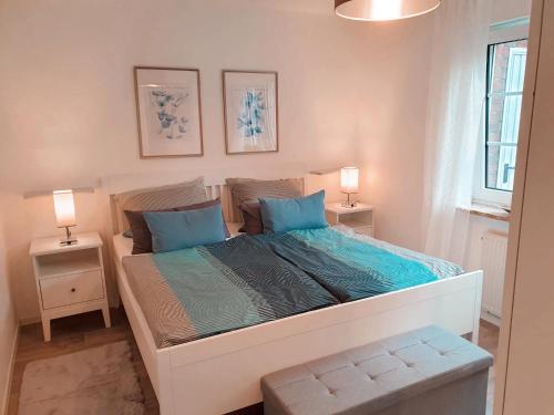 a bedroom with a large bed with blue pillows at Fewo Rosalie in Norddeich
