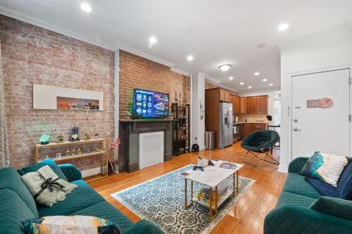 a living room with a blue couch and a brick wall at Large Home Near NYC In Hoboken Sleeps 6 in Hoboken