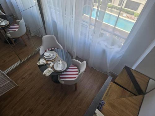 een woonkamer met een tafel en stoelen en een raam bij Acogedor, inolvidable in Montevideo