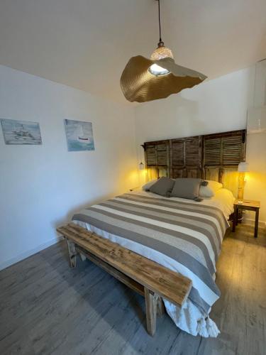 um quarto com uma cama grande e um banco de madeira em Ô sparolland em Saint-Mandrier-sur-Mer