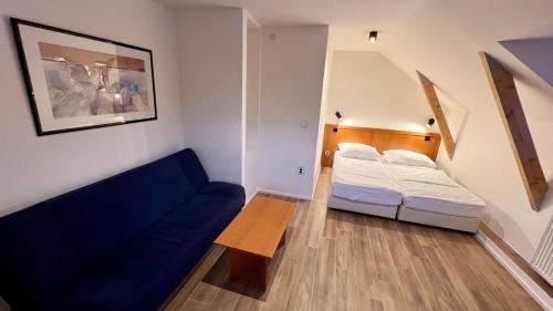 a small room with a bed and a couch at Wellness Penzion HORSE FARM in Bravantice