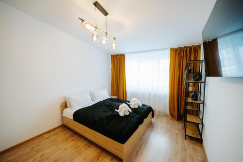 een slaapkamer met een bed met een zwarte deken bij Modern Studio in Ipoteşti