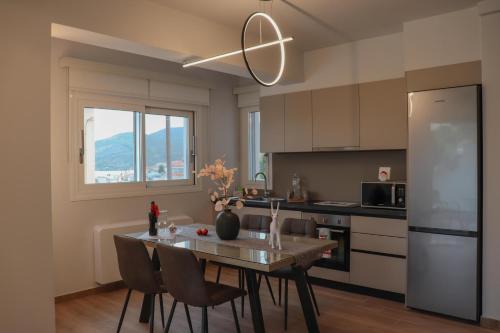 a kitchen with a table and chairs and a refrigerator at Elia Luxury Residence in Chalkida