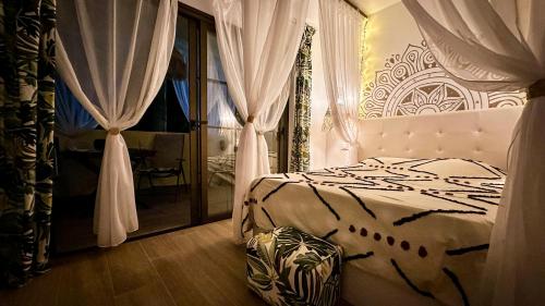a bedroom with a bed and a window with curtains at The Green Hut - Costa Adeje in Adeje