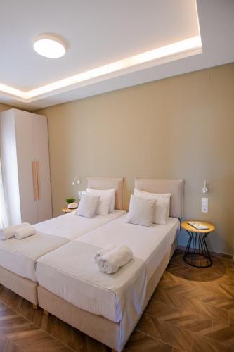 a bedroom with two beds with white sheets at Marble Luxury Suites in Karteros