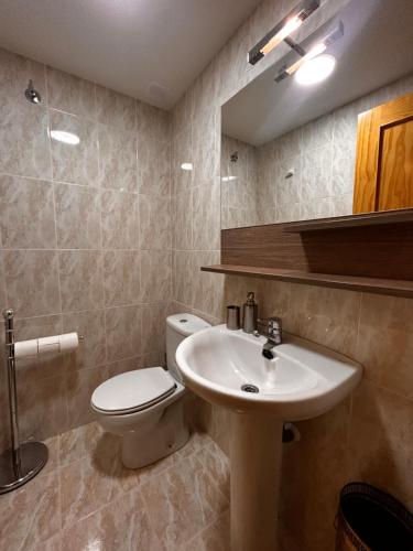 y baño con aseo blanco y lavamanos. en Formigal Valle del tena Rural Home, en Formigal