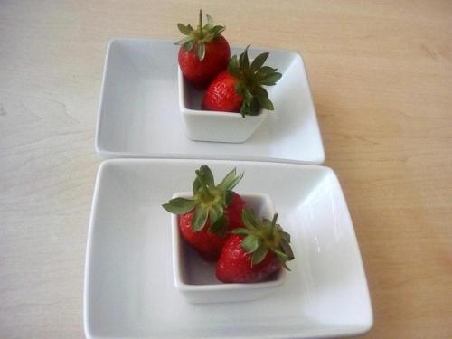 trzy białe płytki z truskawkami na stole w obiekcie Plk Noord Guesthouse w mieście Polokwane