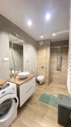 a bathroom with a washing machine and a toilet at Apartament Złocień in Krakow