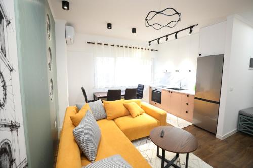 a living room with a yellow couch and a kitchen at Tirana Center Apartment - Your Cosy Corner in Tirana