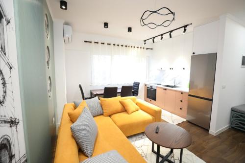 Una sala de estar con un sofá amarillo y una cocina. en Tirana Center Apartment - Your Cosy Corner, en Tirana