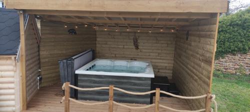 a hot tub sitting inside of a wooden building at Les Cabanes du Grand Nord in Pradines
