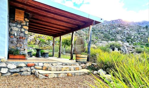 a stone house with a wooden roof with a stone pathway at Fairfield Cottages in Ceres