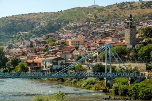 a blue bridge over a river with a city at Garden Oasis Apartment in Veles
