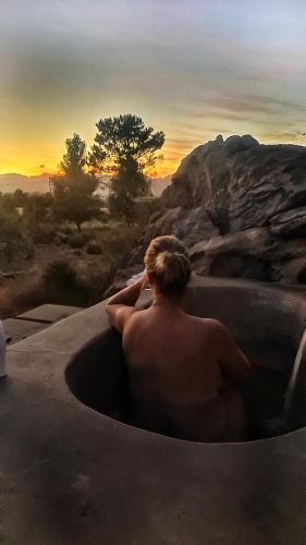 a man sitting in a bath tub watching the sunset at Fairfield Cottages in Ceres