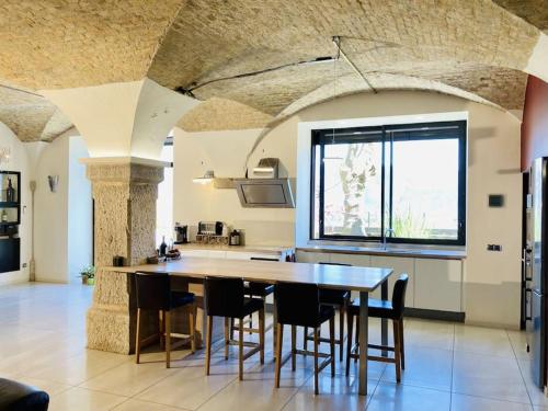 a kitchen with a table and chairs in a room at Ancien domaine de Chartreux avec jacuzzi in Tullins