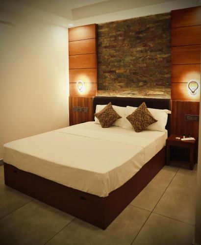 a bedroom with a large bed with two pillows at Silverstone Inn in Nedumbassery