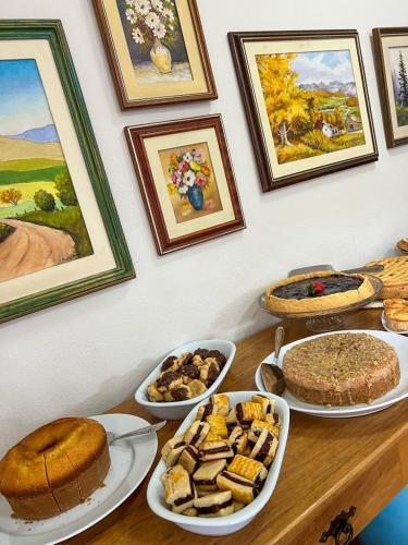 a table with several plates of food on it at Pousada Flor de Lua Monte Verde in Monte Verde