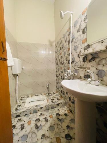 a bathroom with a sink and a toilet at Airport Hotel Bed & Rest in Karachi