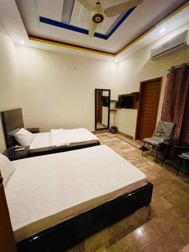 a bedroom with two beds and a ceiling at Airport Hotel Bed & Rest in Karachi