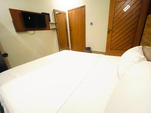 a hotel room with a bed and a television at Airport Hotel Bed & Rest in Karachi