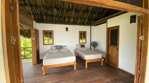 1 dormitorio con 2 camas y puerta abierta en Playa Cangrejo, en Moñitos