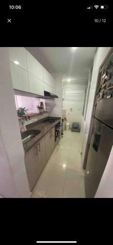 uma cozinha branca com um lavatório e um frigorífico em Host Apt• central em Pereira
