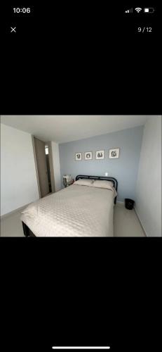 um quarto com uma cama branca num quarto em Host Apt• central em Pereira
