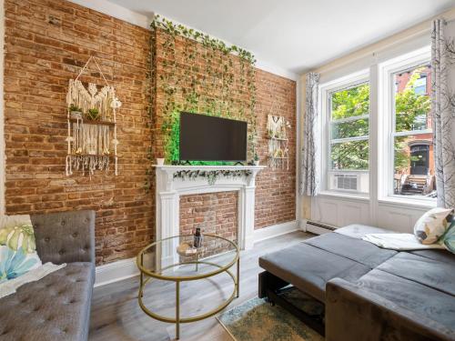 uma sala de estar com uma parede de tijolos em Minutes to NYC Sleeps 5 em Hoboken