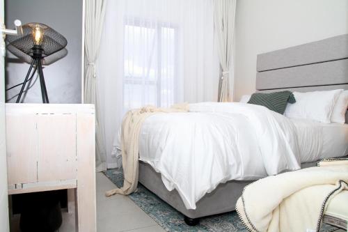 a bedroom with a white bed and a fireplace at Sublime - By LaSerene - Carlswald in Midrand